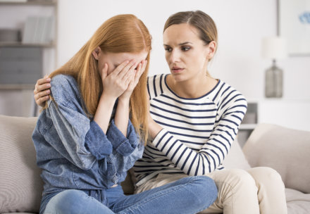 woman comforting another woman