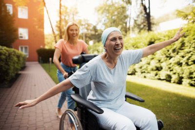 A woman with cancer is sitting in a wheelchair